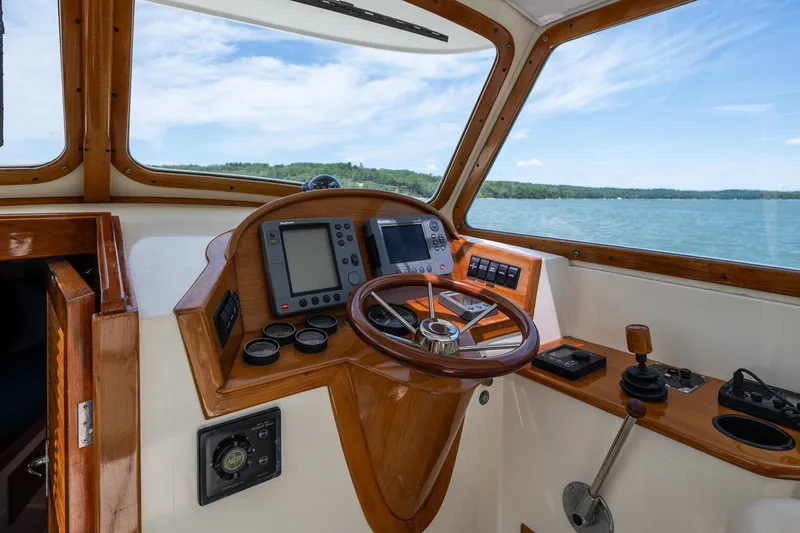 Slide: The Image of Helm of 2000 Hinckley Picnic Boat 36 Classic with wooden accents and navigational equipment. - 19