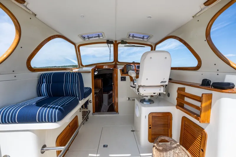 Slide: The Image of Interior of 2000 Hinckley Picnic Boat 36 Classic with striped seating and wooden accents. - 15