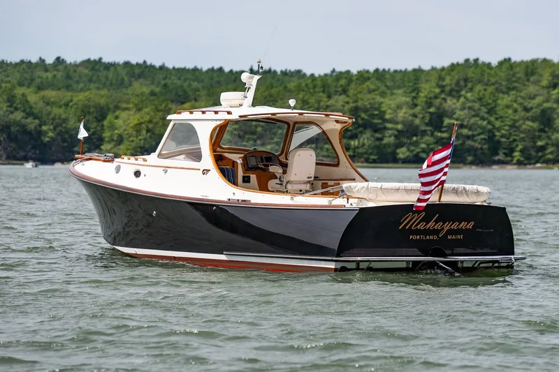 Slide: The Image of 2000 Hinckley Picnic Boat 36 Classic on water, displaying American flag, lush green background. - 33
