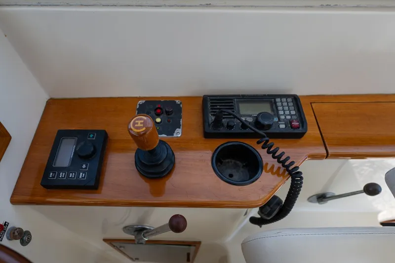 Slide: The Image of Hinckley Picnic Boat 36 Classic 2000 helm controls with radio and joystick on wooden panel. - 21