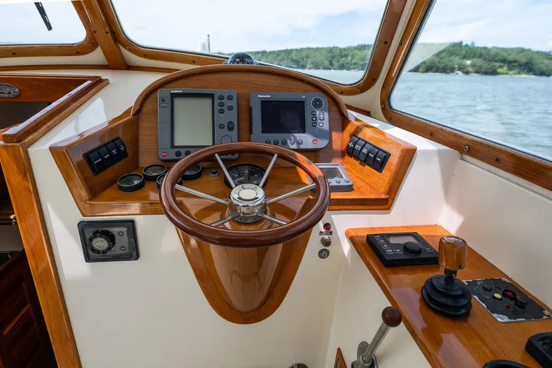 Slide: The Image of Helm of 2000 Hinckley Picnic Boat 36 Classic with wooden steering wheel and navigation instruments. - 20