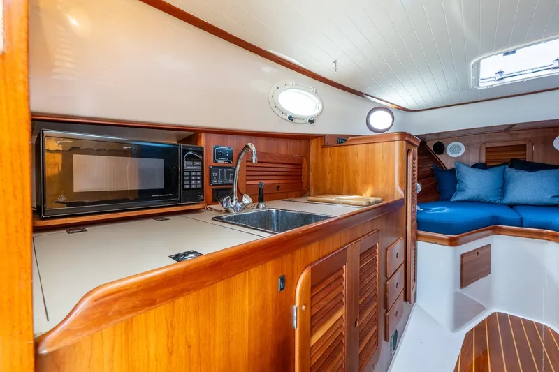 Slide: The Image of Hinckley Picnic Boat 36 Classic 2000 interior with kitchenette and seating area. - 23