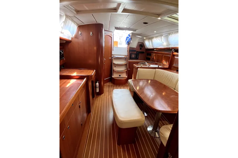 Slide: The Image of Interior of 2006 Beneteau Oceanis 393 yacht, featuring elegant wood finishes and cozy seating. - 16