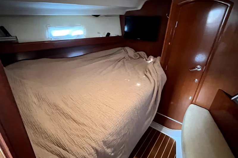 Slide: The Image of Cozy cabin interior of 2006 Beneteau Oceanis 393 sailboat with bed and wooden finish. - 39