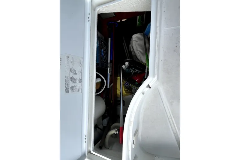 Slide: The Image of Storage compartment of a 2006 Beneteau Oceanis 393 sailboat, containing various equipment and supplies. - 83