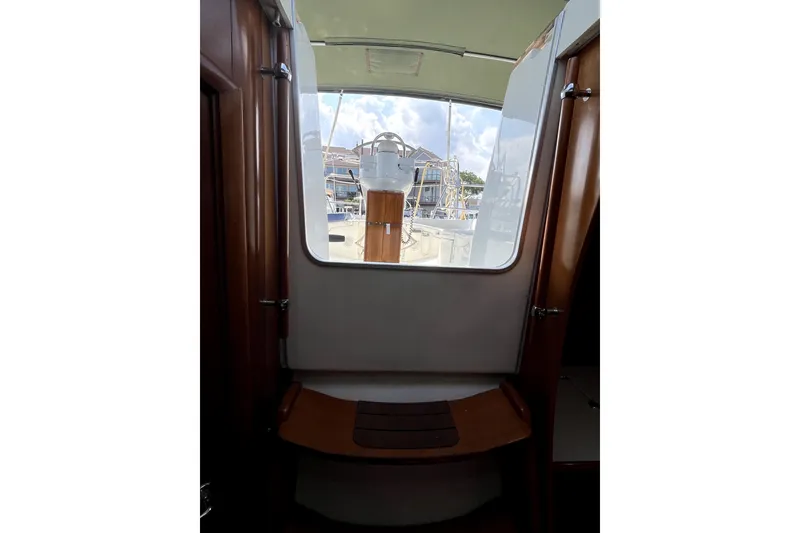 Slide: The Image of Interior view of 2006 Beneteau Oceanis 393 sailboat, showcasing cockpit entrance and wooden details. - 36