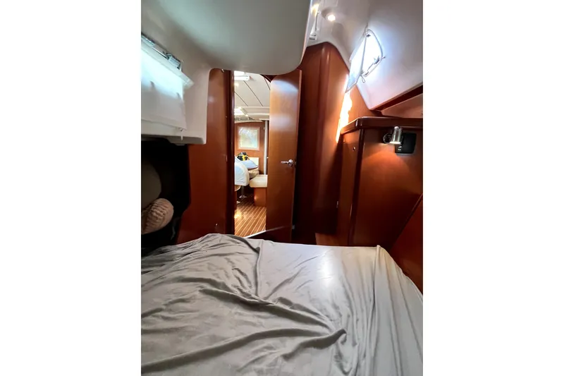 Slide: The Image of Interior cabin view of a 2006 Beneteau Oceanis 393 sailboat, featuring cozy wooden furnishings. - 30