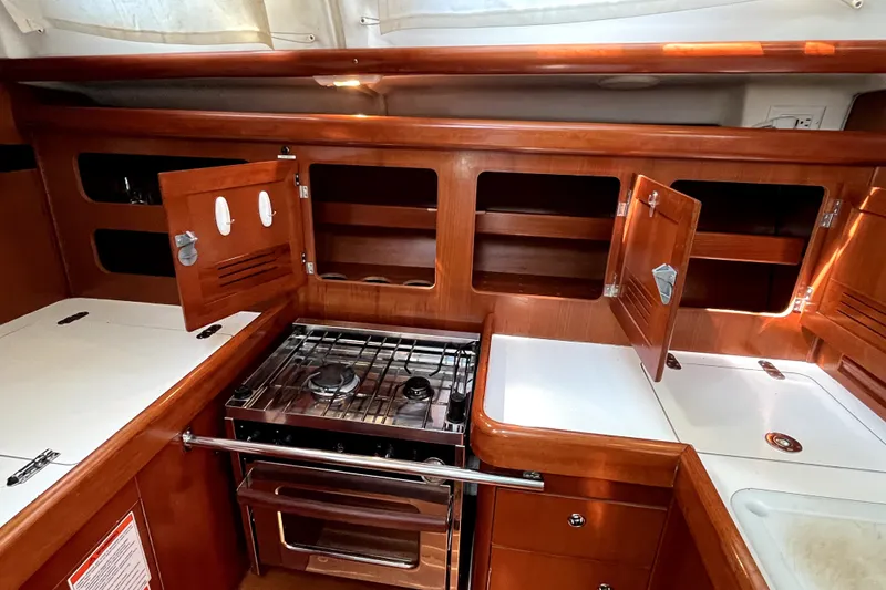 Slide: The Image of Interior of 2006 Beneteau Oceanis 393 yacht kitchen with wooden cabinets and stove. - 19