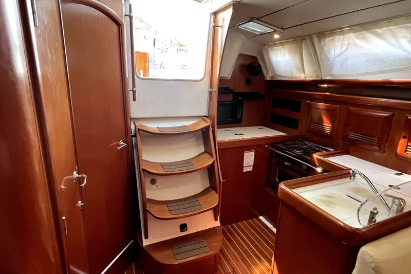 Slide: The Image of Interior of 2006 Beneteau Oceanis 393 sailboat with wooden cabinetry and compact kitchen. - 20