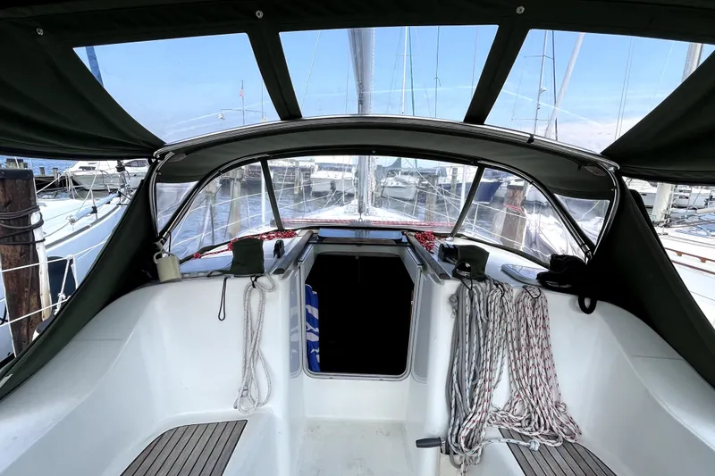 Slide: The Image of Cockpit view of a 2006 Beneteau Oceanis 393 sailboat, docked at a marina. - 58