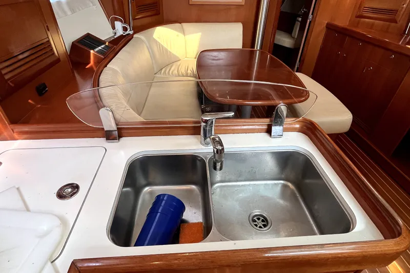 Slide: The Image of Interior of 2006 Beneteau Oceanis 393 yacht featuring a kitchen sink and cozy seating area. - 24