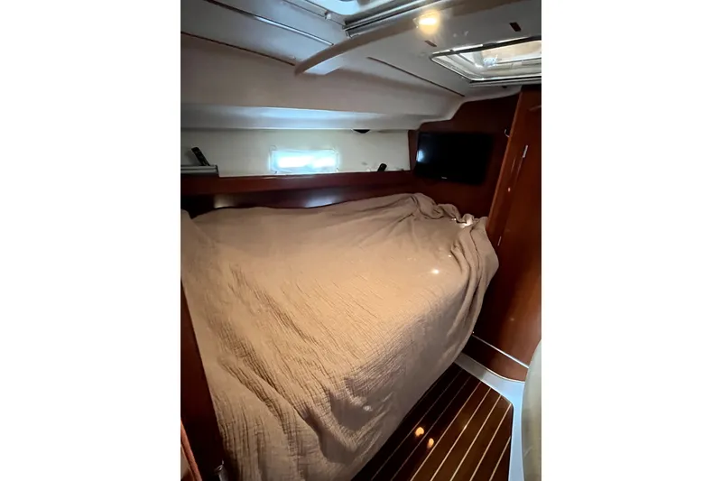 Slide: The Image of Interior cabin of 2006 Beneteau Oceanis 393 yacht with cozy bed and wooden finish. - 38