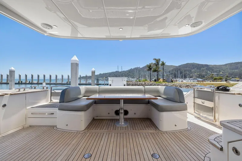 Slide: The Image of Luxurious 2015 Princess 60 Flybridge Motor Yacht deck with seating and scenic marina view. - 13