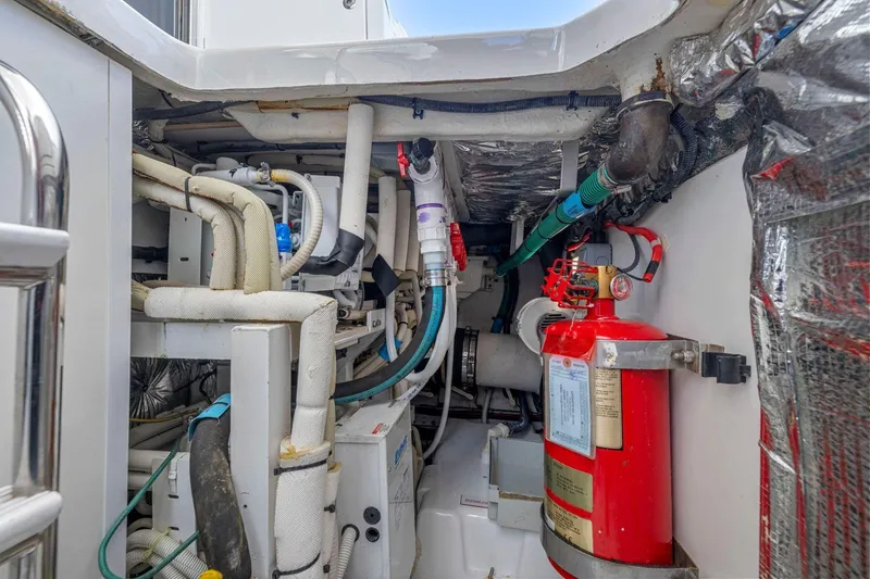 Slide: The Image of Engine room of a 2015 Princess 60 Flybridge Motor Yacht with fire extinguisher and piping. - 61