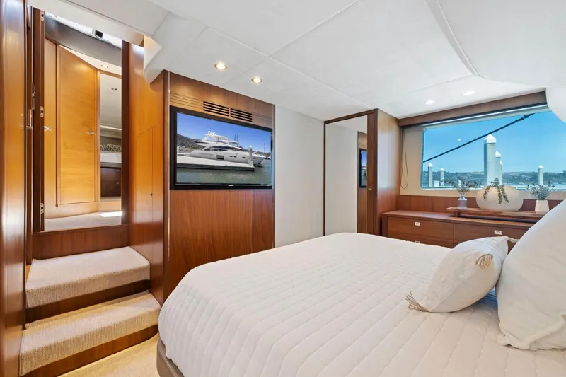 Slide: The Image of Luxurious 2015 Princess 60 Flybridge Motor Yacht bedroom with elegant wood finishes and scenic window view. - 37