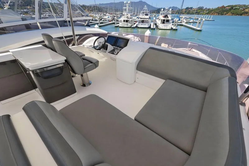 Slide: The Image of Luxurious 2015 Princess 60 Flybridge Motor Yacht interior with seating and helm, docked at marina. - 56