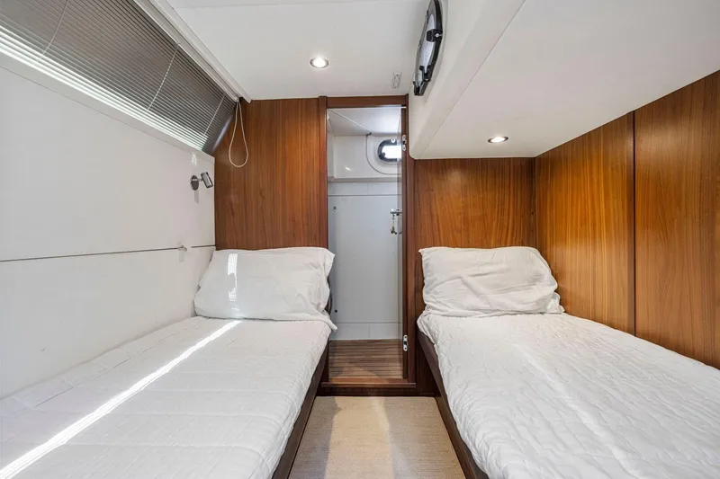 Slide: The Image of Twin cabin interior of 2015 Princess 60 Flybridge Motor Yacht, featuring wood paneling and cozy beds. - 49