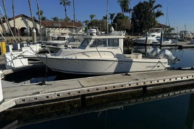 Slide: The Image of 2022 Defiance Admiral 250 EX boat docked in a marina with palm trees. - 16
