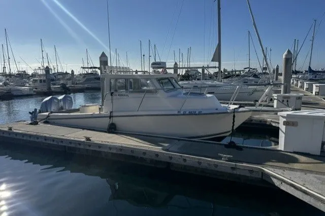 The Image of 2022 Defiance Admiral 250 EX boat docked at a marina under clear blue skies. - 0