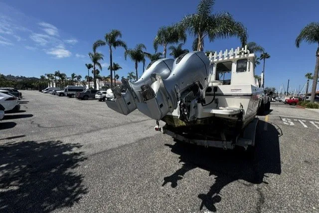 Slide: The Image of 2022 Defiance Admiral 250 EX boat with dual outboard motors in a sunny parking lot. - 17