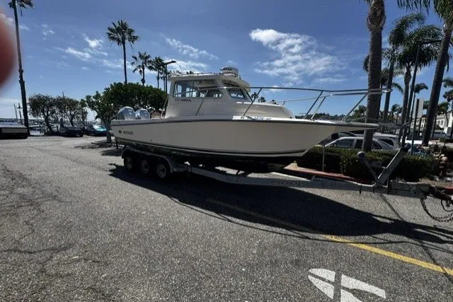 Slide: The Image of 2022 Defiance Admiral 250 EX boat on trailer, parked near palm trees under a clear sky. - 16