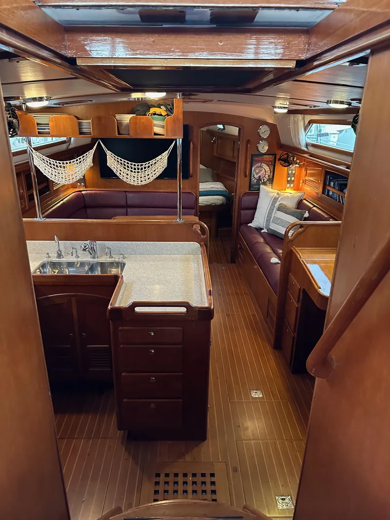 Slide: The Image of Interior of 2008 Outbound 46 sailboat with wood finish, cozy seating, and kitchen area. - 37