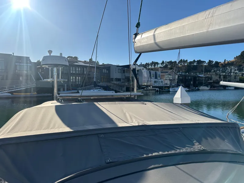 Slide: The Image of Sailboat docked in marina, Outbound 46 model, sunny day, waterfront homes in background. - 16