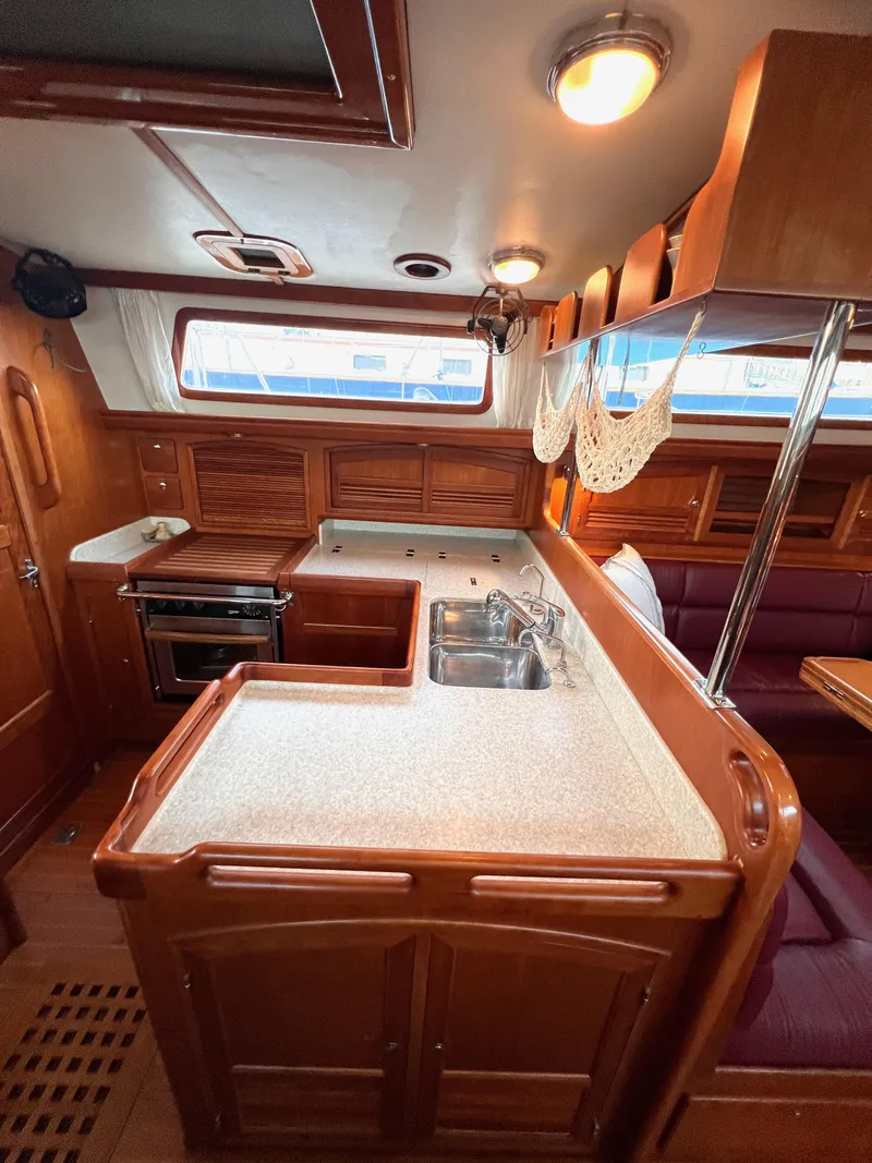Slide: The Image of 2008 Outbound 46 yacht interior with wooden cabinetry and modern kitchen amenities. - 41