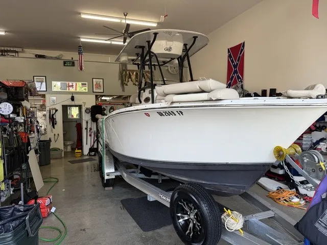The Image of A 2016 NauticStar 2302 Legacy boat is in a garage on a trailer. - 1