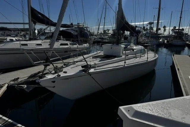 The Image of 1973 Custom BILL LEE 40 sailboat docked in a marina, surrounded by other boats. - 0