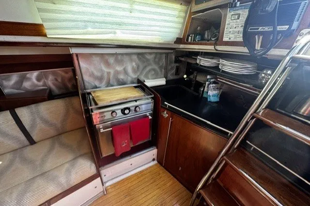 Slide: The Image of Interior of a 1973 Custom BILL LEE 40 yacht, featuring a compact kitchen area. - 28