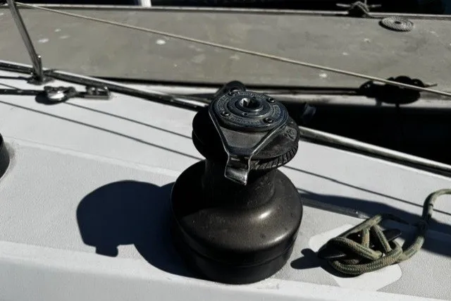 Slide: The Image of Winch on 1973 Custom BILL LEE 40 sailboat deck, with rope and railing visible. - 10
