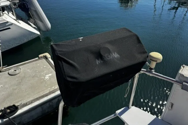 Slide: The Image of Covered grill on a 1973 Custom BILL LEE 40 sailboat docked by the water. - 12