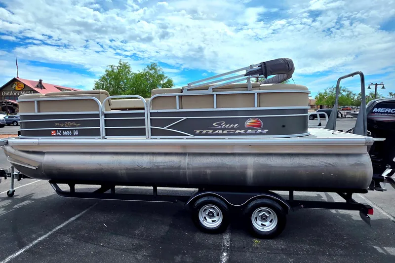 The Image of 2019 Sun Tracker Party Barge 20 DLX pontoon boat on trailer in parking lot. - 0