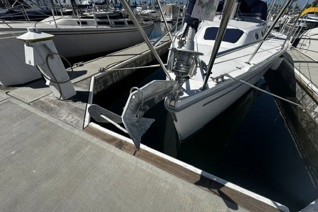 Slide: The Image of Catalina 320 sailboat from 2000 docked at a marina, featuring a prominent anchor. - 2