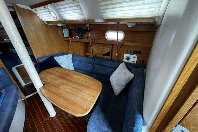 Slide: The Image of Cozy interior of a 2000 Catalina 320 sailboat with blue seating and wooden table. - 17