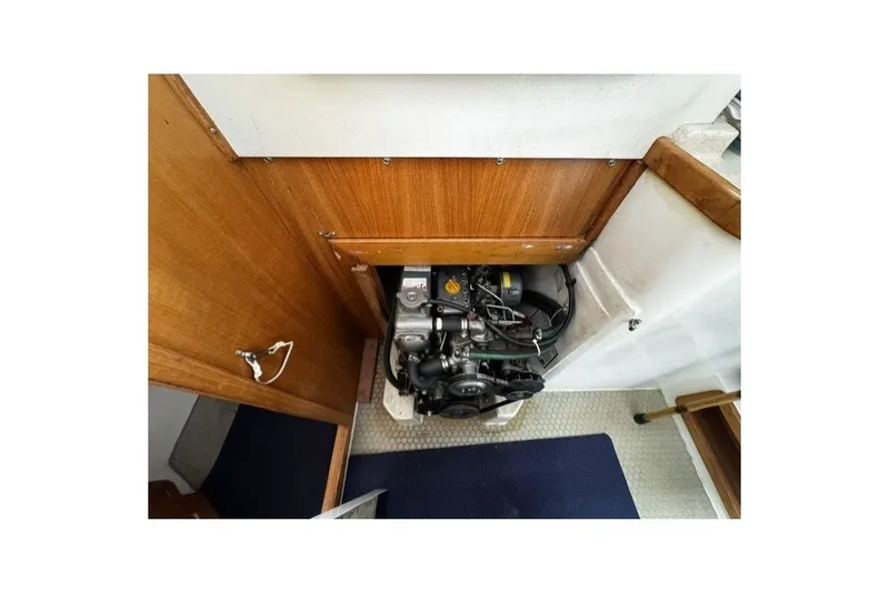 Slide: The Image of Engine compartment of a 2000 Catalina 320 sailboat, featuring a compact marine engine. - 12