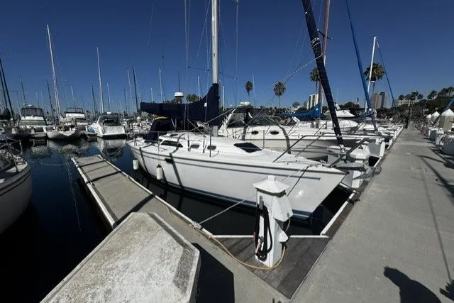 The Image of 2000 Catalina 320 sailboat docked in a marina under clear blue skies. - 0