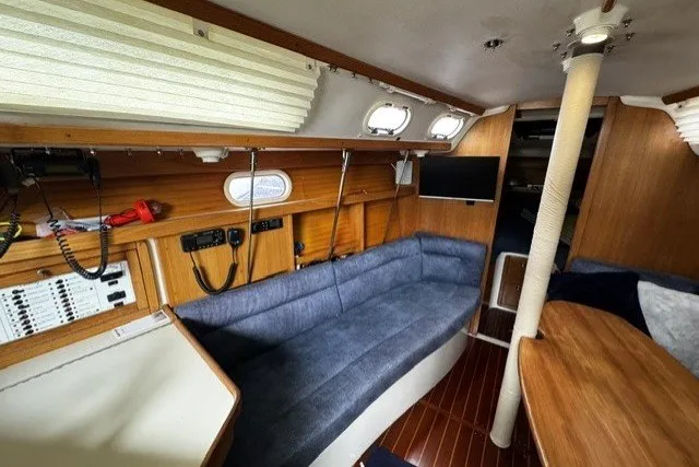 Slide: The Image of Interior of a 2000 Catalina 320 sailboat with blue seating and wooden accents. - 16