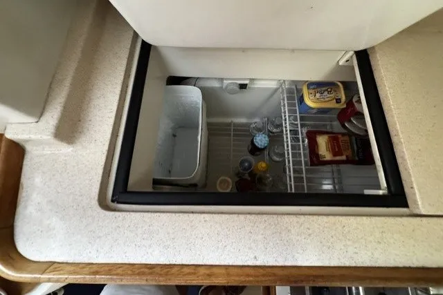 Slide: The Image of Refrigerator inside a 2000 Catalina 320 yacht, stocked with drinks and food items. - 26