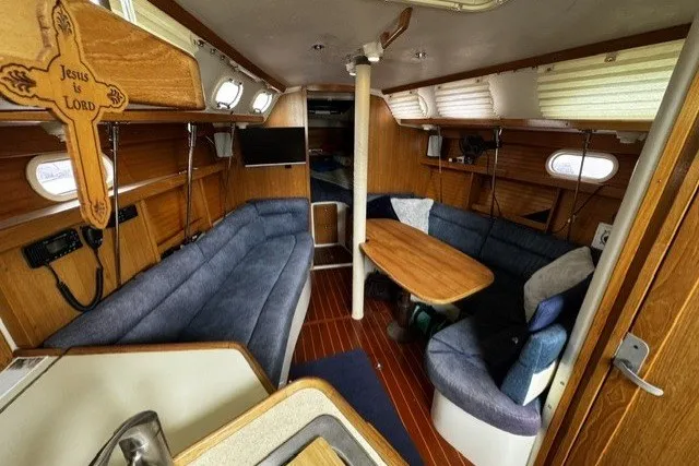Slide: The Image of Interior of a 2000 Catalina 320 sailboat with cozy seating and wooden accents. - 15