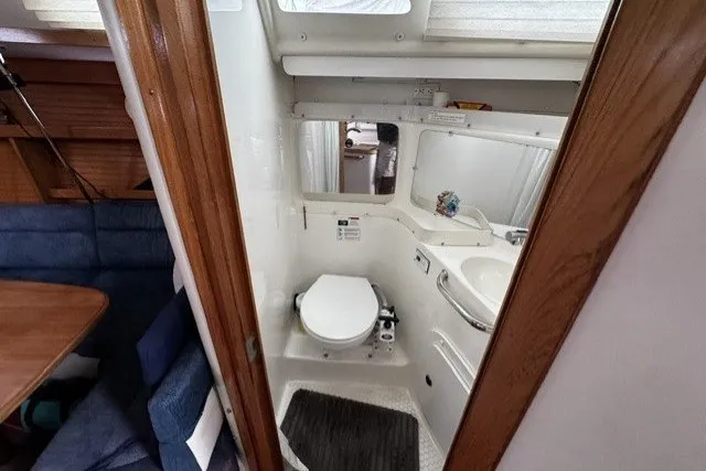 Slide: The Image of Compact bathroom in a 2000 Catalina 320 sailboat, featuring a toilet and sink. - 14
