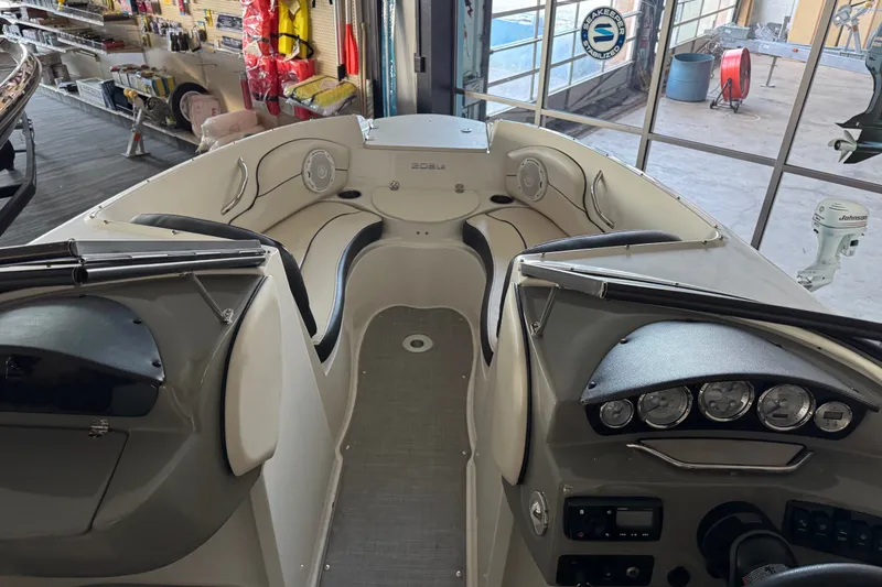 Slide: The Image of 2021 Stingray 208 LR boat interior with dashboard and seating in a showroom. - 9