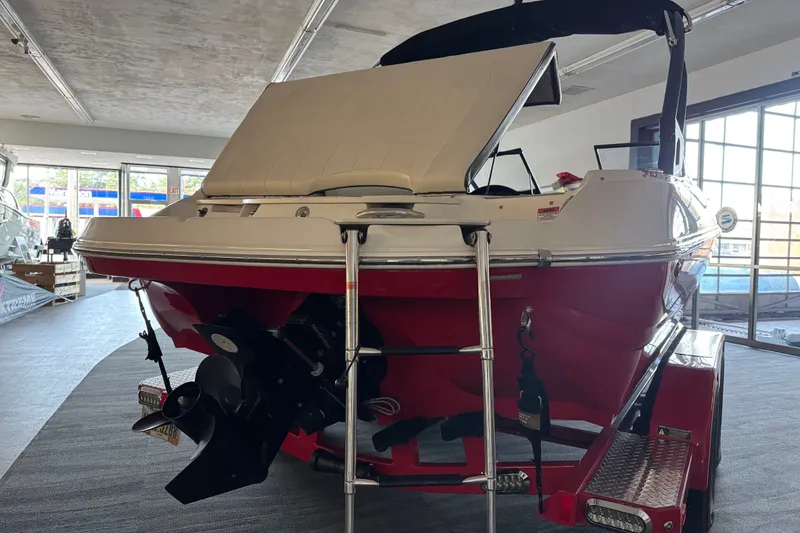 Slide: The Image of 2021 Stingray 208 LR boat in showroom, featuring red hull and swim ladder. - 8