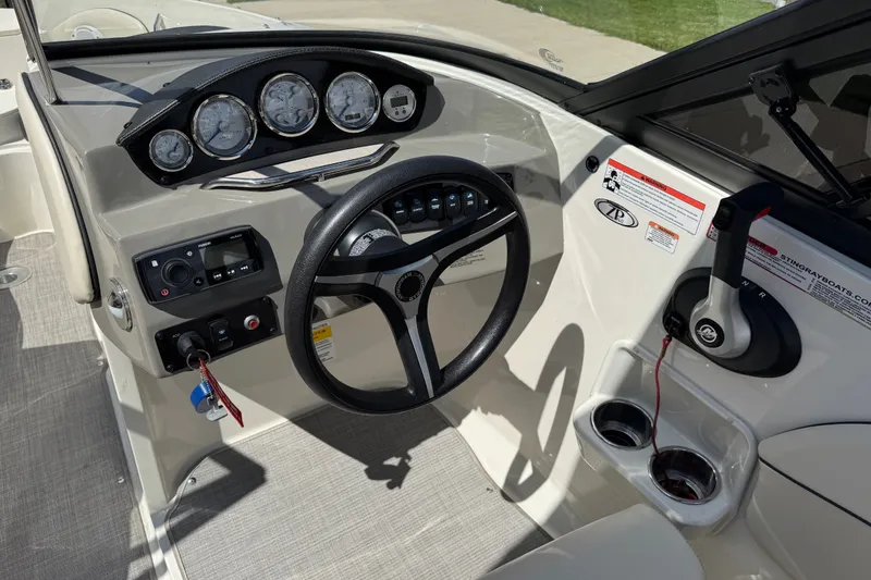 Slide: The Image of 2021 Stingray 208 LR boat dashboard with steering wheel, gauges, and controls. - 17