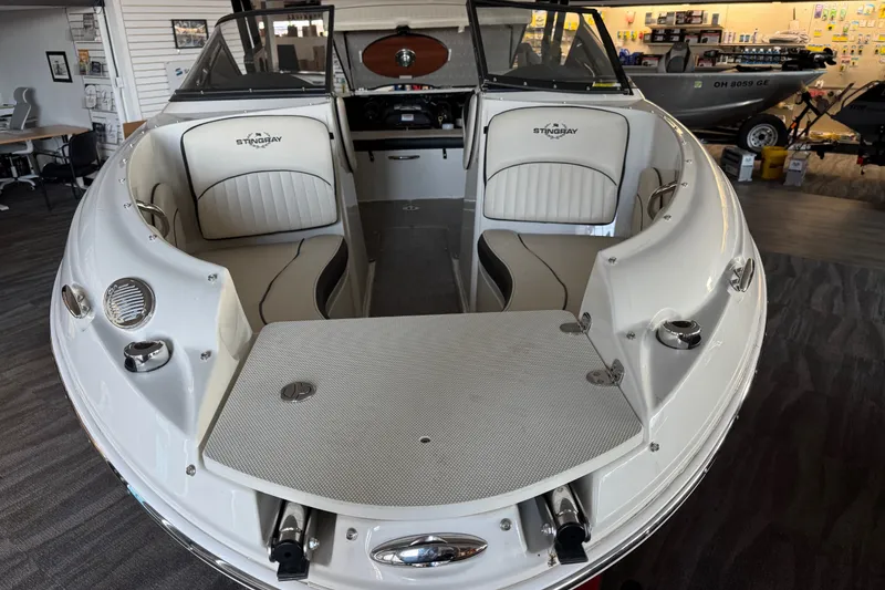 Slide: The Image of 2021 Stingray 208 LR boat interior with seating and dashboard in showroom setting. - 20