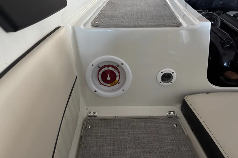 Slide: The Image of 2021 Stingray 208 LR boat interior with fire extinguisher access and seating area. - 14