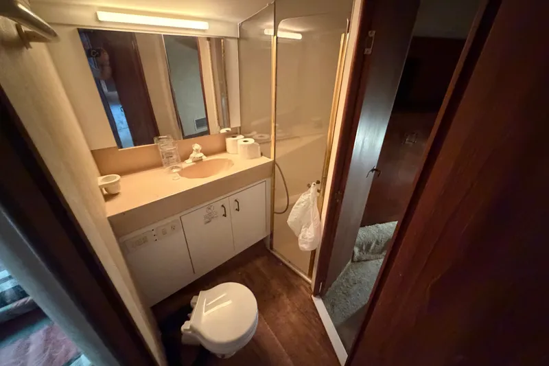 Slide: The Image of Bathroom interior of 1997 Fifth Ocean Yachts 40, featuring sink, toilet, and shower. - 13