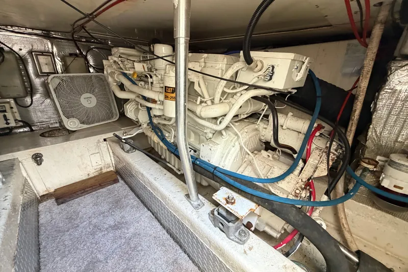 Slide: The Image of Engine room of 1997 Fifth Ocean Yachts 40, featuring a CAT engine and ventilation fan. - 14