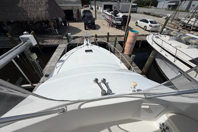 Slide: The Image of Fifth Ocean Yachts 40, 1997 model, docked at a marina with surrounding boats. - 6